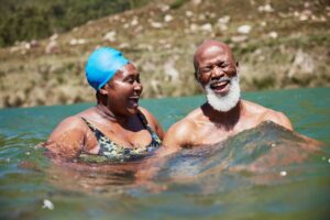 Elderly couple swimming together.